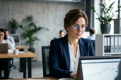 Femme dirigeante analysant les finances de son entreprise sur un ordinateur portable dans un bureau moderne