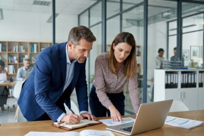 Expert-comptable et entrepreneur discutant de la création d'une société autour de documents financiers dans un bureau moderne