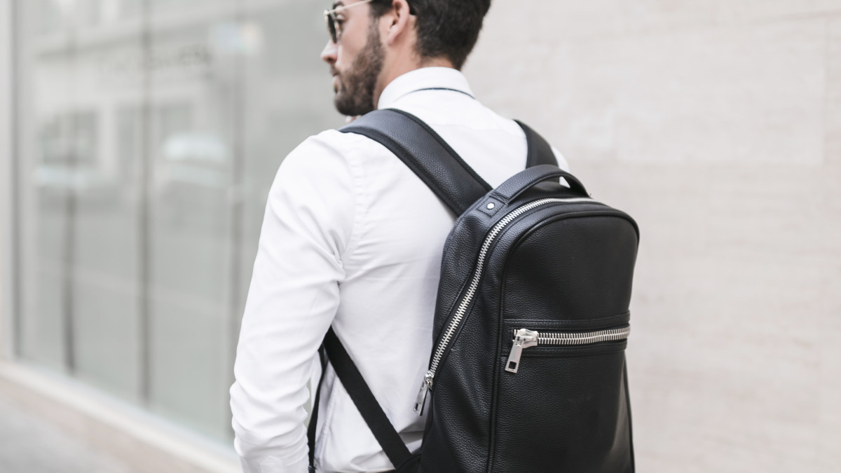 homme d'affaire portant un sac a dos