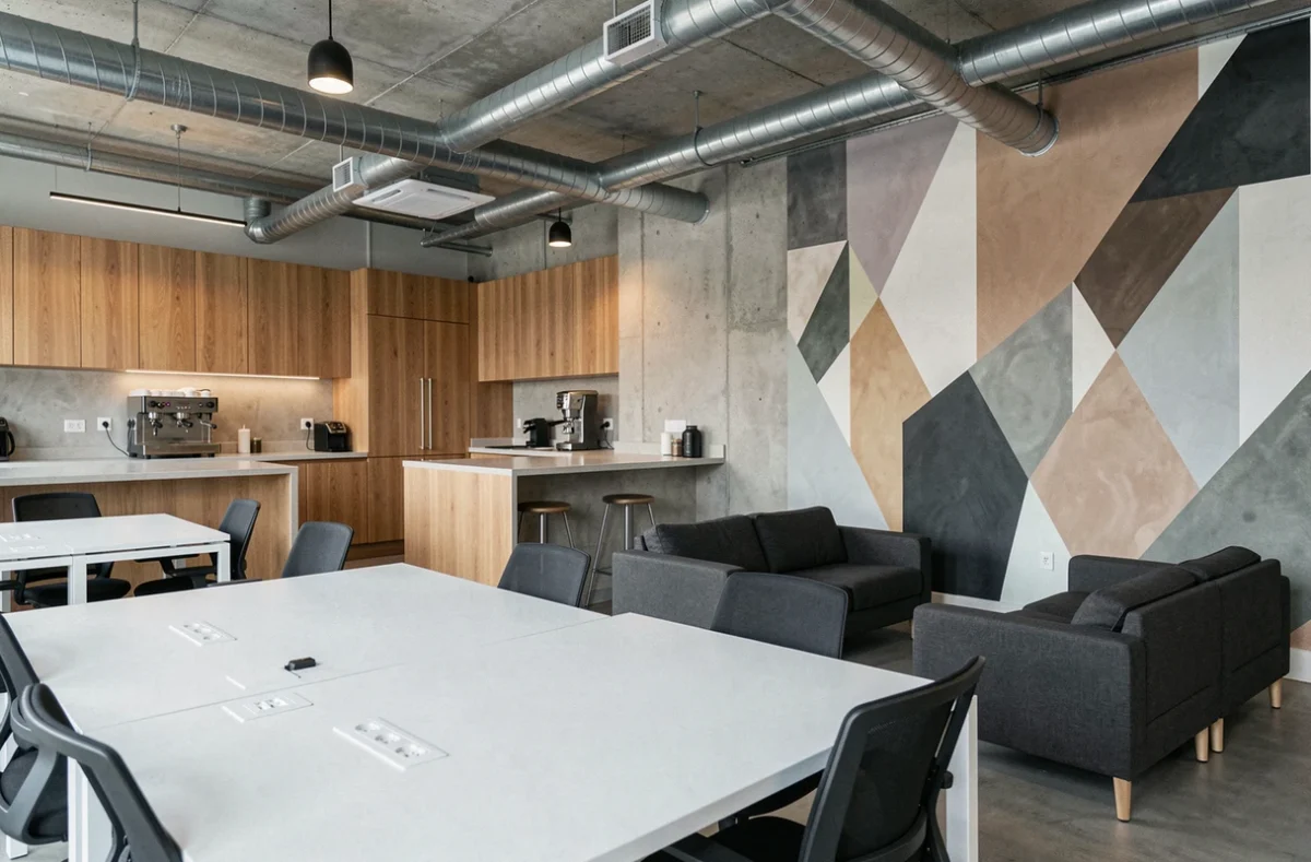 Vue intérieure d'un espace de coworking vide et moderne à Issy-les-Moulineaux avec cuisine commune et postes de travail ergonomiques